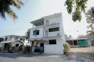 a white building with a sign in front of it at Aashray Guestroom in Murud