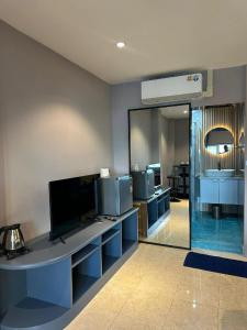 a large room with a television and a mirror at Puttaya Glow in Pattaya