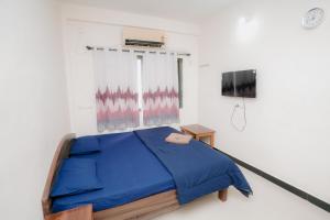 a bedroom with a blue bed and a tv at Aashray Guestroom in Murud