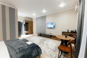 a bedroom with a bed and a table in it at AURA hotel in Taraz