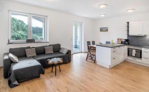 a living room with a couch and a kitchen at Ferienhof Broger FeWo Obstbäumle mit Pool in Neukirch