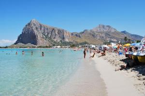 a beach with a bunch of people in the water at Mariposa B&B in San Vito lo Capo