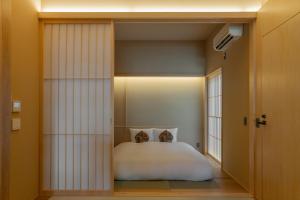 a bedroom with a white bed and a window at NEW2025! Shirakaba ROKUI 白樺 緑居 Architect-designed Luxury Villa with Concierge Service in Osaka