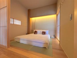 a bedroom with a white bed in a room at NEW2025! Shirakaba ROKUI 白樺 緑居 Architect-designed Luxury Villa with Concierge Service in Osaka