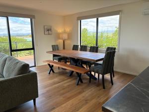 a dining room with a table and chairs and windows at 45 degrees South in Kakanui