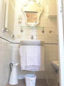 W łazience znajduje się umywalka, lustro i ręczniki. w obiekcie Spello House Dormio w mieście Spello