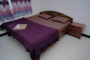 a bedroom with a large bed and a wooden nightstand at Aashray Guestroom in Murud