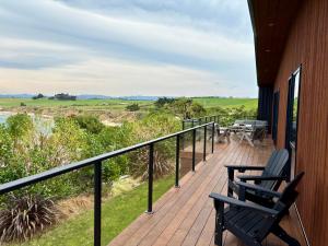 a deck with two chairs and a bench on a house at 45 degrees South in Kakanui +9 photos