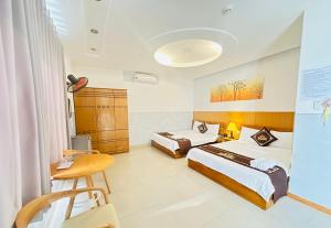 a hotel room with two beds and a desk at KHÁCH SẠN PHÚ HƯNG in Ho Chi Minh City
