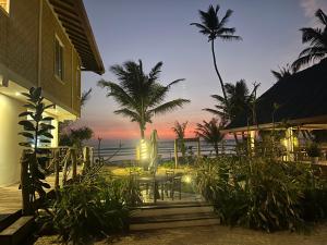 a resort patio with a table and chairs and the ocean at Beach Garden in Weligama +14 photos