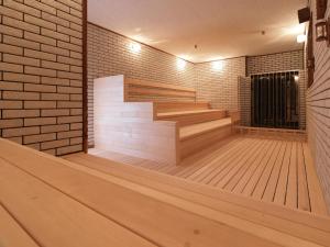a empty room with wooden stairs and a brick wall at Hotel Emisia Sapporo in Sapporo