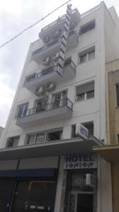 a tall white building with a hotel sign on it at Hotel Ionion in Piraeus +18 photos