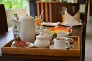 a table with a tray with tea pots and cups at Fortwill City Hotel in Galle