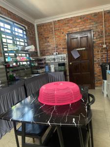 a pink lid on a table in a kitchen at Homestay Anjang in Tapah