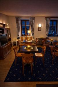 a living room with tables and chairs and a television at Hotel Oberje Dla Viere Oulx - Check-in Automatico 24h in Oulx