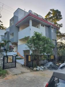 a white house with a gate in front of it at Guru Villa in Yercaud