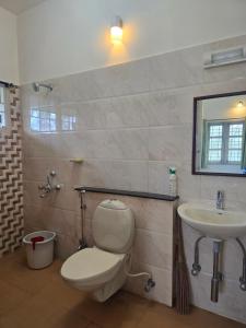 a bathroom with a toilet and a sink at Guru Villa in Yercaud
