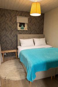 a bedroom with a large bed with a blue blanket at Pauna Puhkemajad in Tori