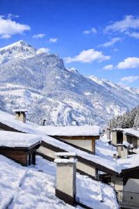 a snow covered roof of a building with a mountain at Hotel Oberje Dla Viere Oulx - Check-in Automatico 24h in Oulx