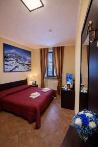 a bedroom with a large red bed and a window at Hotel Oberje Dla Viere Oulx - Check-in Automatico 24h in Oulx +90 photos