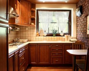 a kitchen with wooden cabinets and a window at Willa Stareczka in Wisła