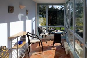 a room with a balcony with a table and chairs at Fewo 1 im Fischerhaus mit Wintergarten und Terrasse in Seedorf