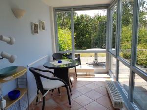 a room with a table and chairs and a window at Fewo 1 im Fischerhaus mit Wintergarten und Terrasse in Seedorf