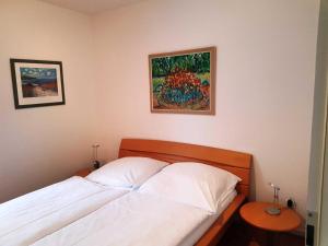 a bedroom with a bed and a painting on the wall at Fewo 1 im Fischerhaus mit Wintergarten und Terrasse in Seedorf