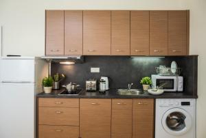 a kitchen with wooden cabinets and a washer and dryer at Modern Apartment Zlatnicka 8 in Prague