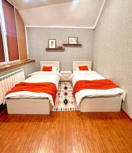 two beds in a small bedroom with wood floors at Holiday Home Kanyon in Argel