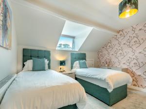 two beds in a attic bedroom with a window at Station View in Pickering +9 photos