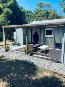 a house with a porch with a couch and a table at Wech Cottage in Warkworth +7 photos