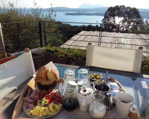 a table with a tray of breakfast food on a balcony at Villa Khepri in Porto Rotondo