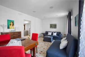 a living room with a blue couch and red chairs at Plaza Suites in Piazza Armerina