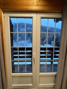 two windows in a room with snow at Le cocon de La Bresse in La Bresse