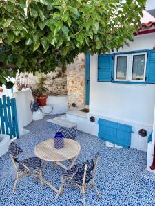 a patio with a table and chairs and a building at Oikies Skiathos in Skiathos