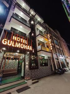 a hotel with a sign on the side of a building at Hotel Gulmohar in Haridwār