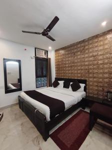 a bedroom with a bed and a ceiling fan at Hotel Gulmohar in Haridwār
