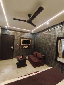 a living room with a couch and a ceiling fan at Hotel Gulmohar in Haridwār