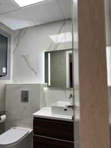 a bathroom with a sink and a toilet and a mirror at Eid Holiday in Muscat +144 photos