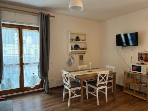 a dining room with a table and chairs and a television at Attico - Terrazza su Castello in Castel di Sangro +24 photos