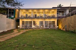 a house with a large yard in front of it at The Coastal Agonda in Agonda