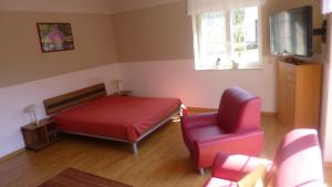 a bedroom with a red bed and a red chair at Haus Schwielochsee in Schwielochsee