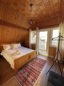 a bedroom with a bed and a large window at Vacation with Purpose in Gura Humorului