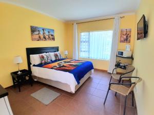 a bedroom with a bed and a large window at Meerkat Manor on Main in Clarens