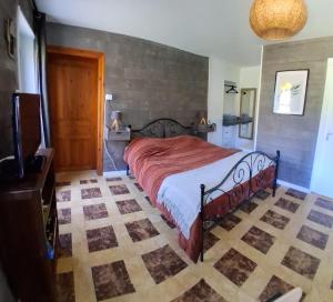 a bedroom with a bed with a red comforter at Chez Claire et Olivier in Nabringhen