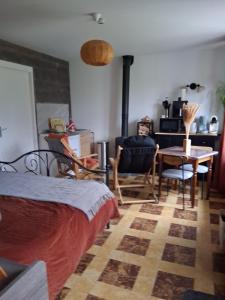 a bedroom with a bed and a table and chairs at Chez Claire et Olivier in Nabringhen
