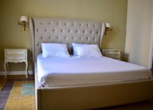 a bed with white sheets and two pillows on it at Grand Arcanum Apartment 2 - Comfortable and Elegant in Senglea