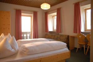 1 dormitorio con 2 camas, sofá y ventanas en Hotel Gasthof Zur Linde, en Rio di Pusteria