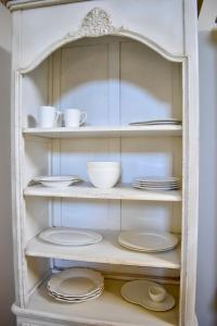 a cabinet filled with plates and bowls and dishes at Grand Arcanum Apartment 2 - Comfortable and Elegant in Senglea